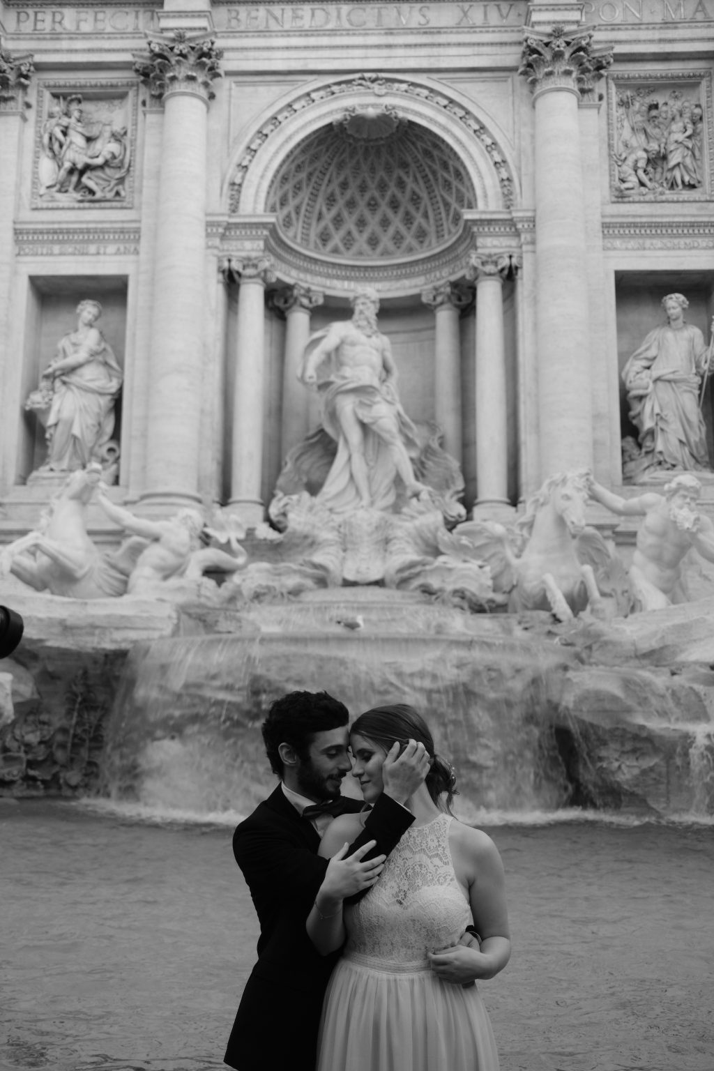 A kiss beneath the statues of the Trevi Fountain, black and white