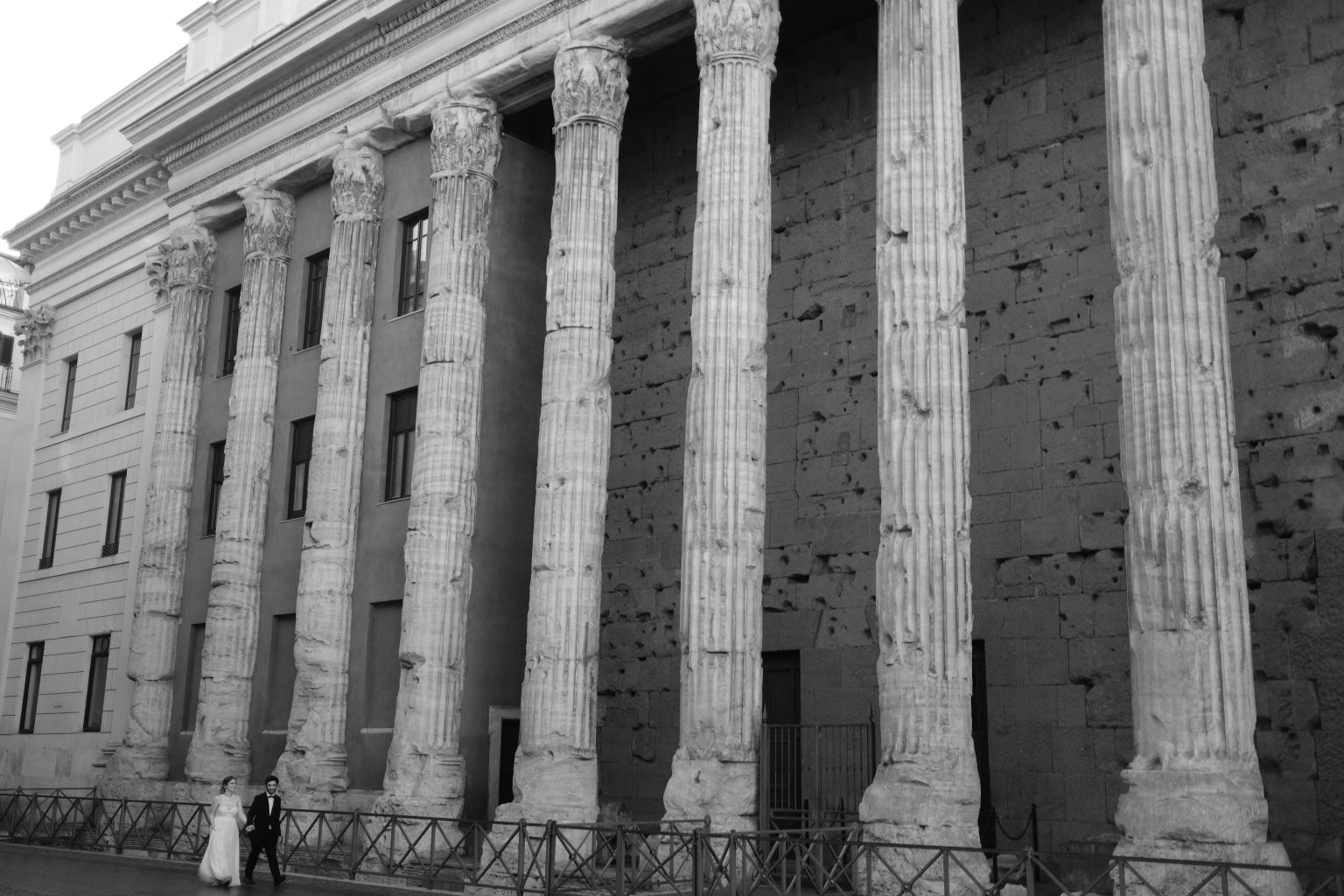 The columns of the Temple of Hadrian with the couple beneath, Rome