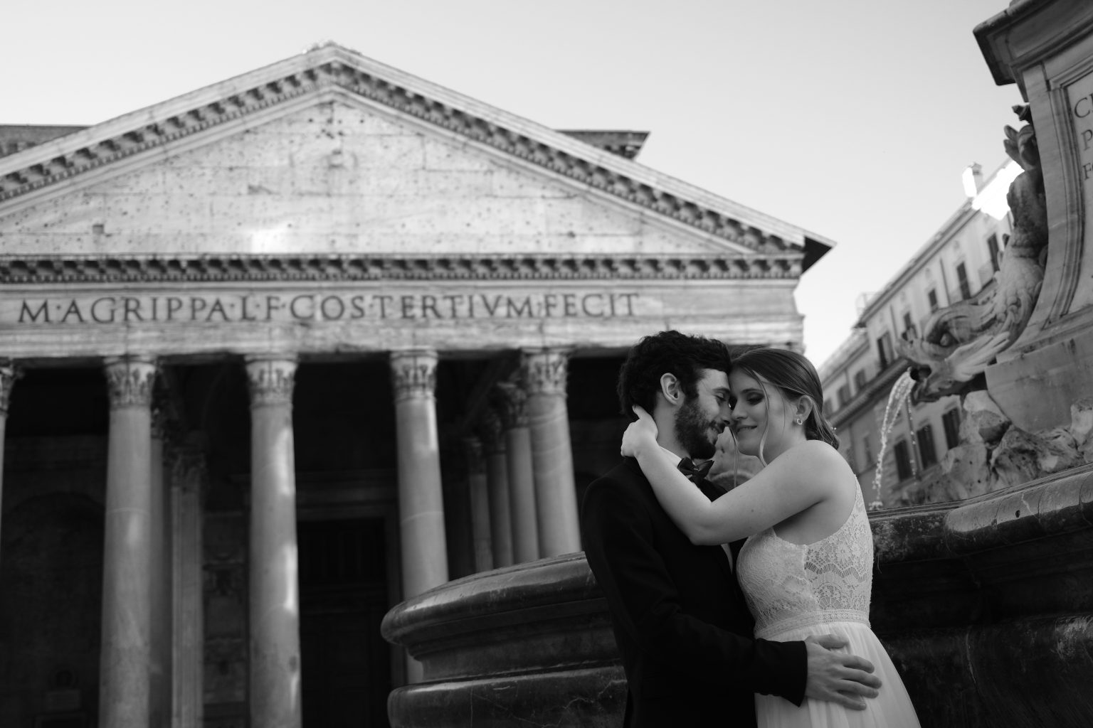 The Pantheon at dawn with the couple embracing below the inscription