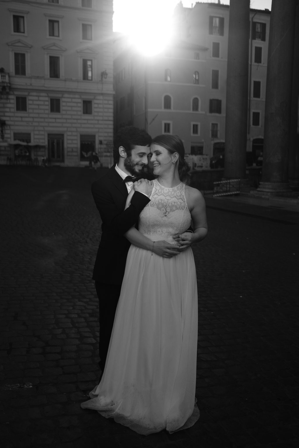 An embrace on a cobbled Roman street at first light