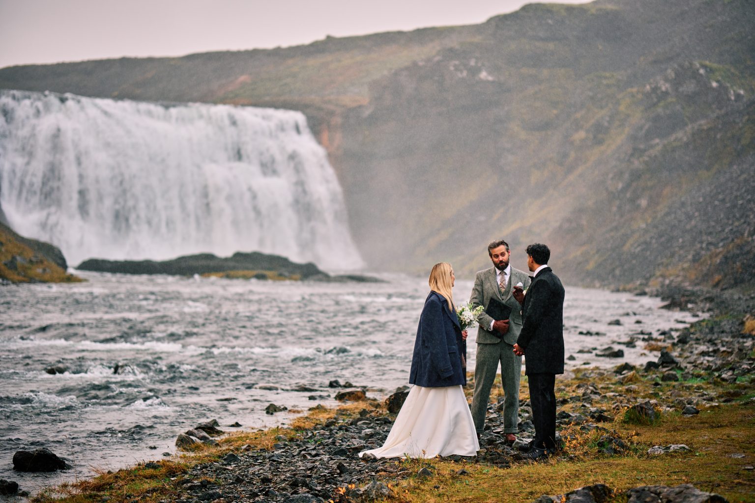 Bride and groom at Þórufoss as the rain begins