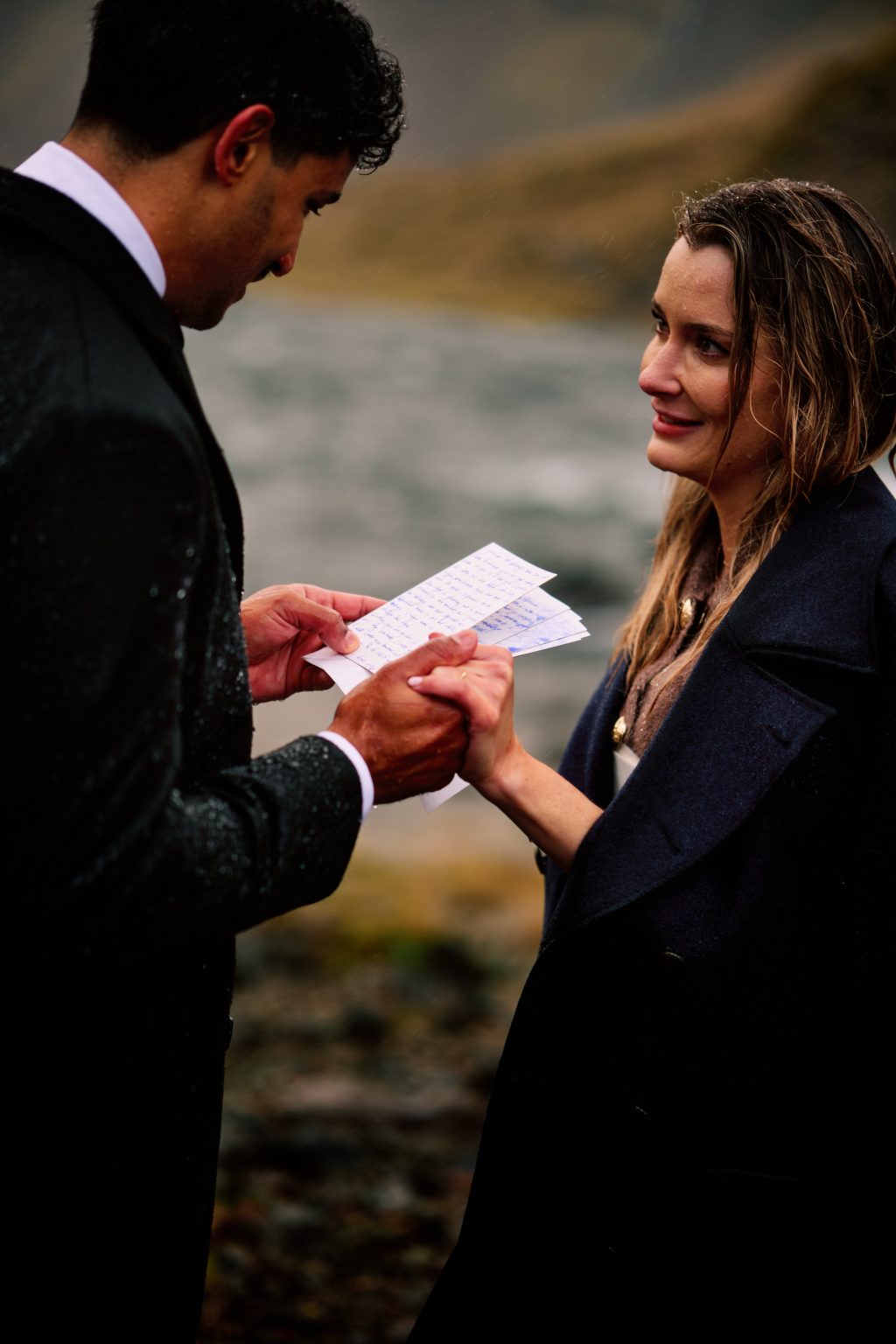 Reading handwritten vows in the pouring rain at an Iceland elopement