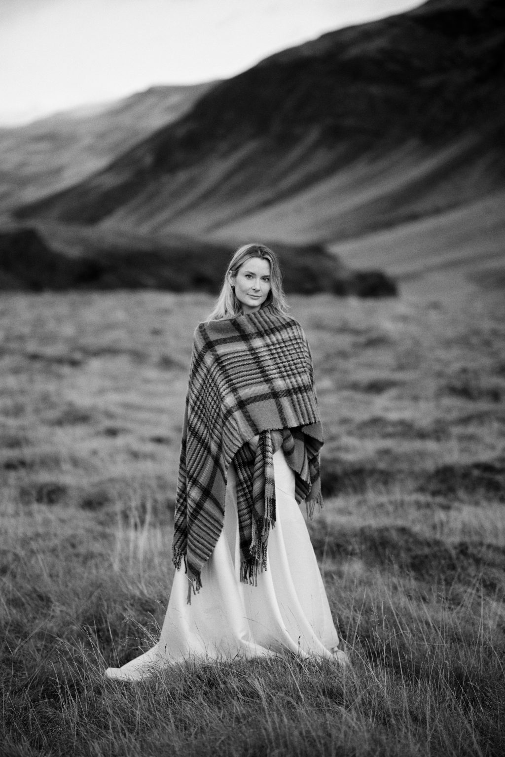 Lindsey wrapped in a wool blanket in the golden fields of Eyrarbakki