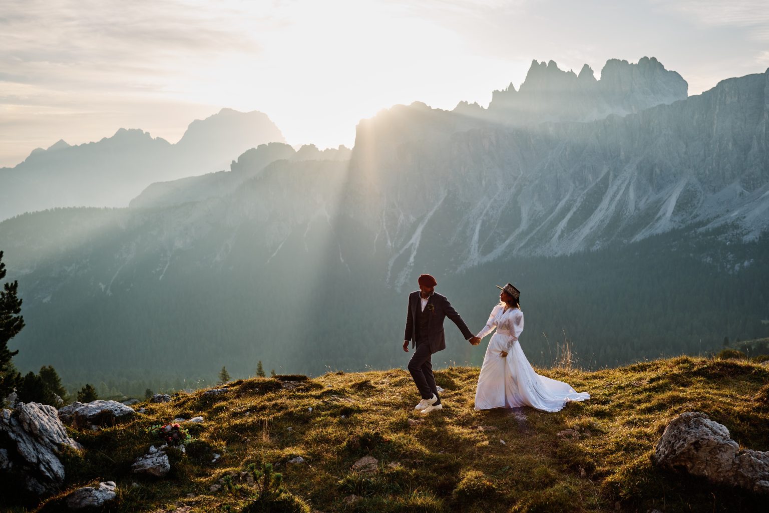 The couple embracing as the sun breaks over the pass