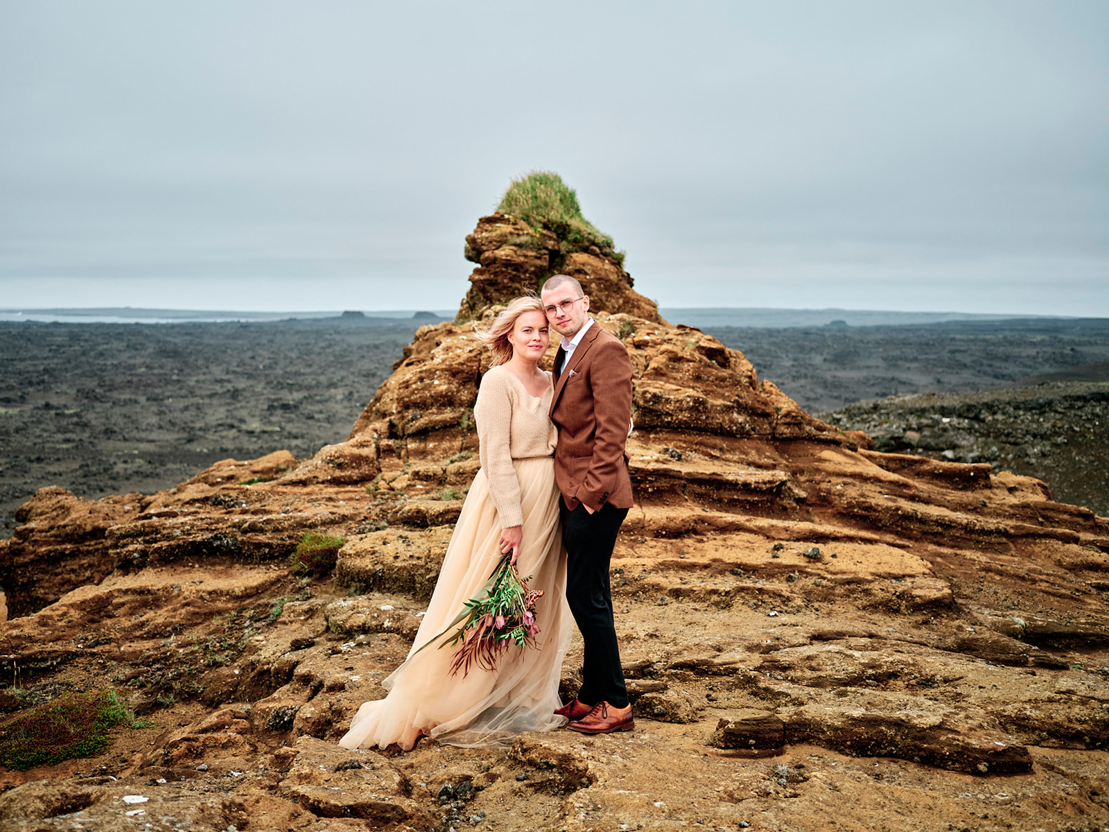 Kim and Daniel on a mossy sea stack, Reykjanes, Iceland