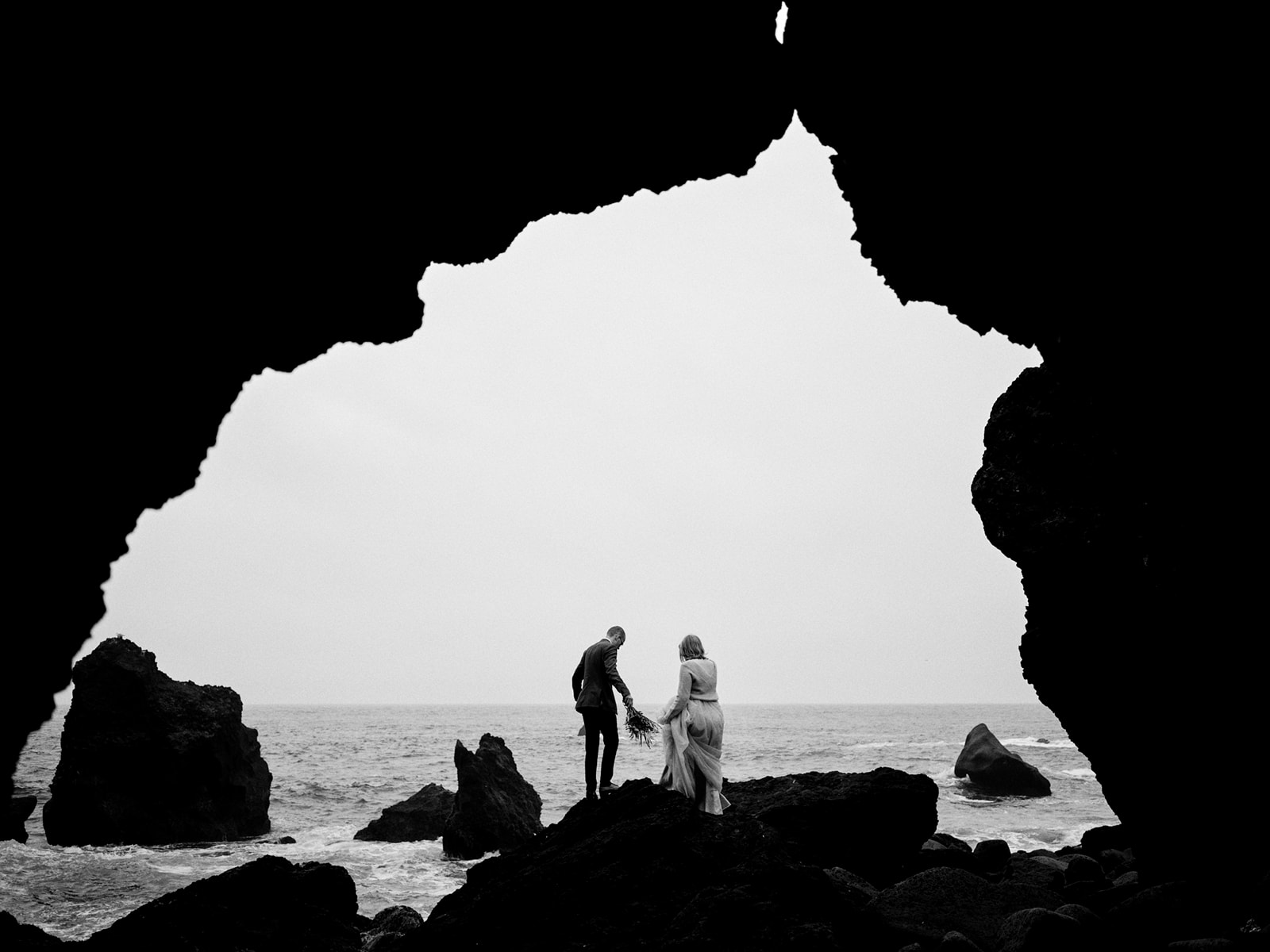 A couple on the black lava coast of Iceland