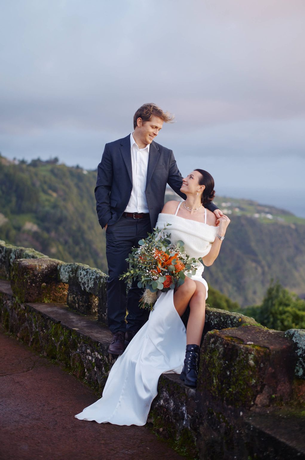 Bride and groom with the bouquet on the cliffs