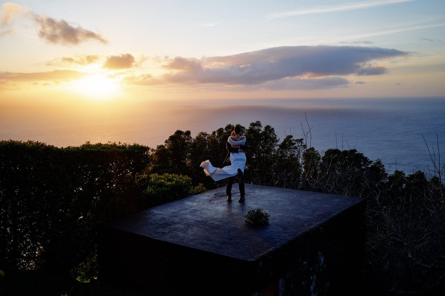 The couple at a clifftop viewpoint at sunset