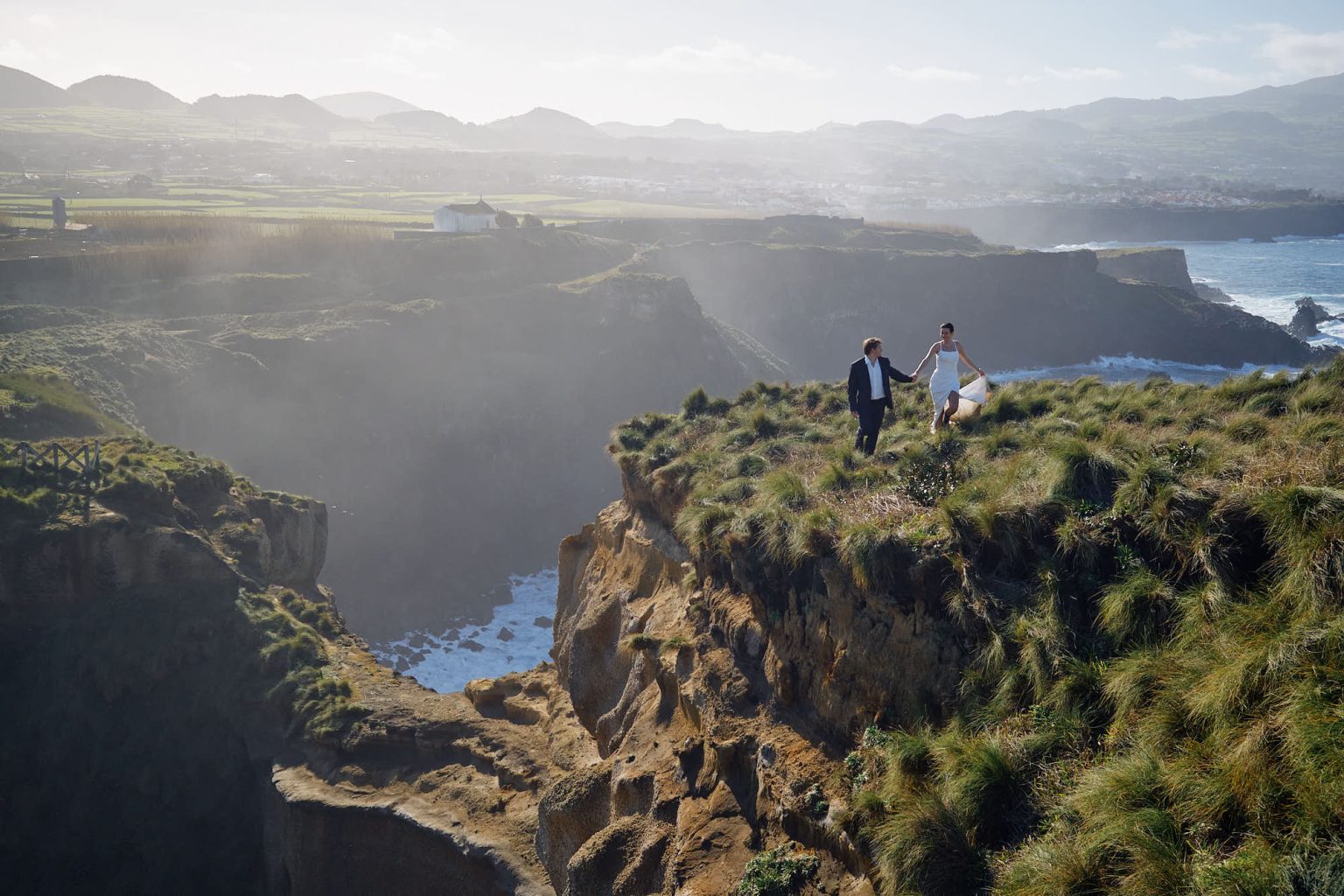 Bride and groom small on a São Miguel cliff edge