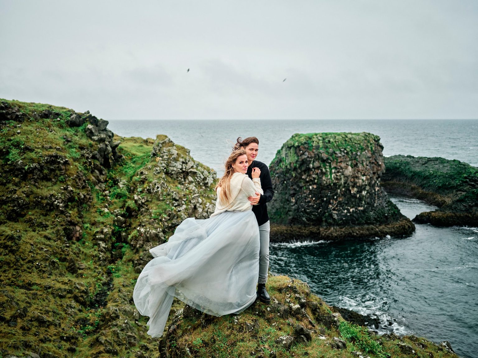 An embrace on the cliff edge, dress in the wind, a Snæfellsnes elopement