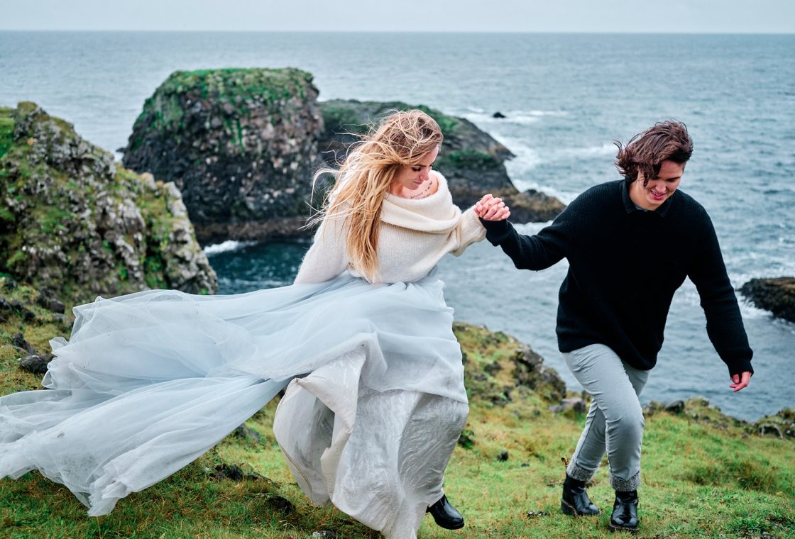 Klara Jenný and Siddy running along the cliff, dress in the wind, a Snæfellsnes elopement