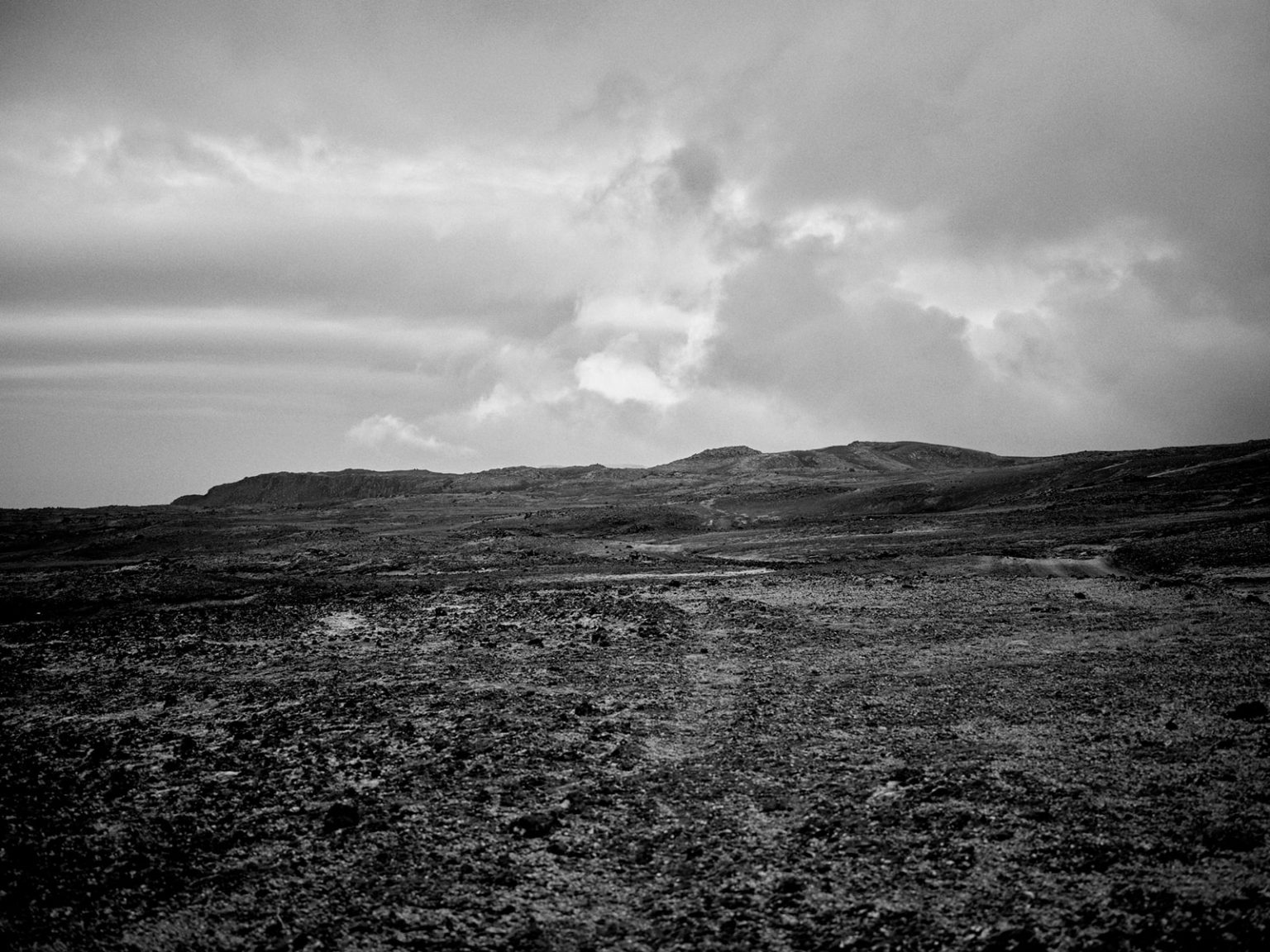 The couple embracing below dramatic clouds, Snæfellsnes, Iceland