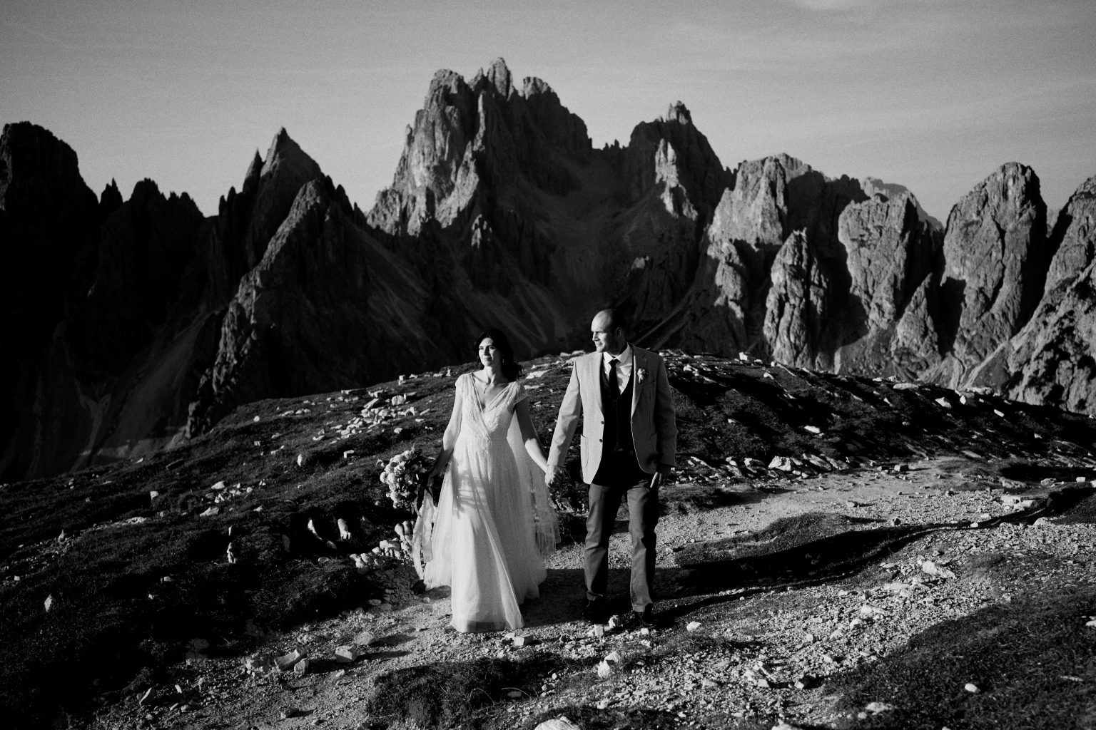 Couple in the rocky basin below Tre Cime di Lavaredo, black and white
