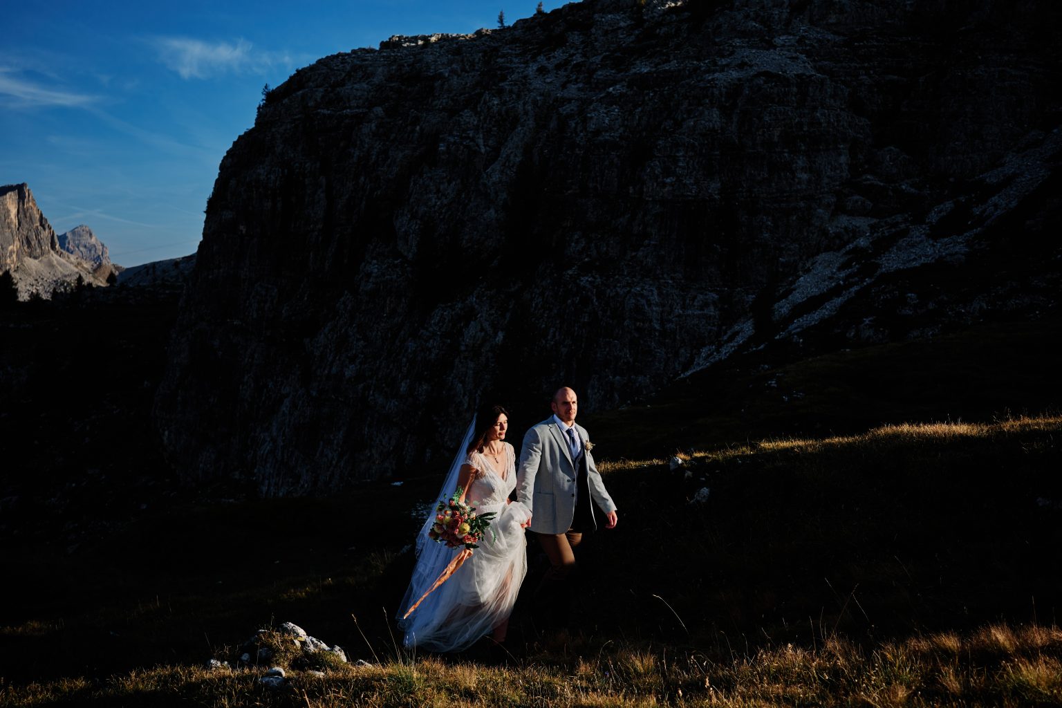 Couple hiking below the towers of the Cinque Torri, Dolomites