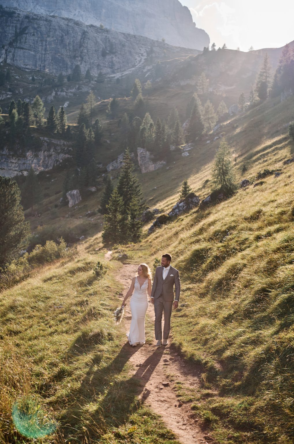 Charlotte and Collin walking the green hillside, Dolomites