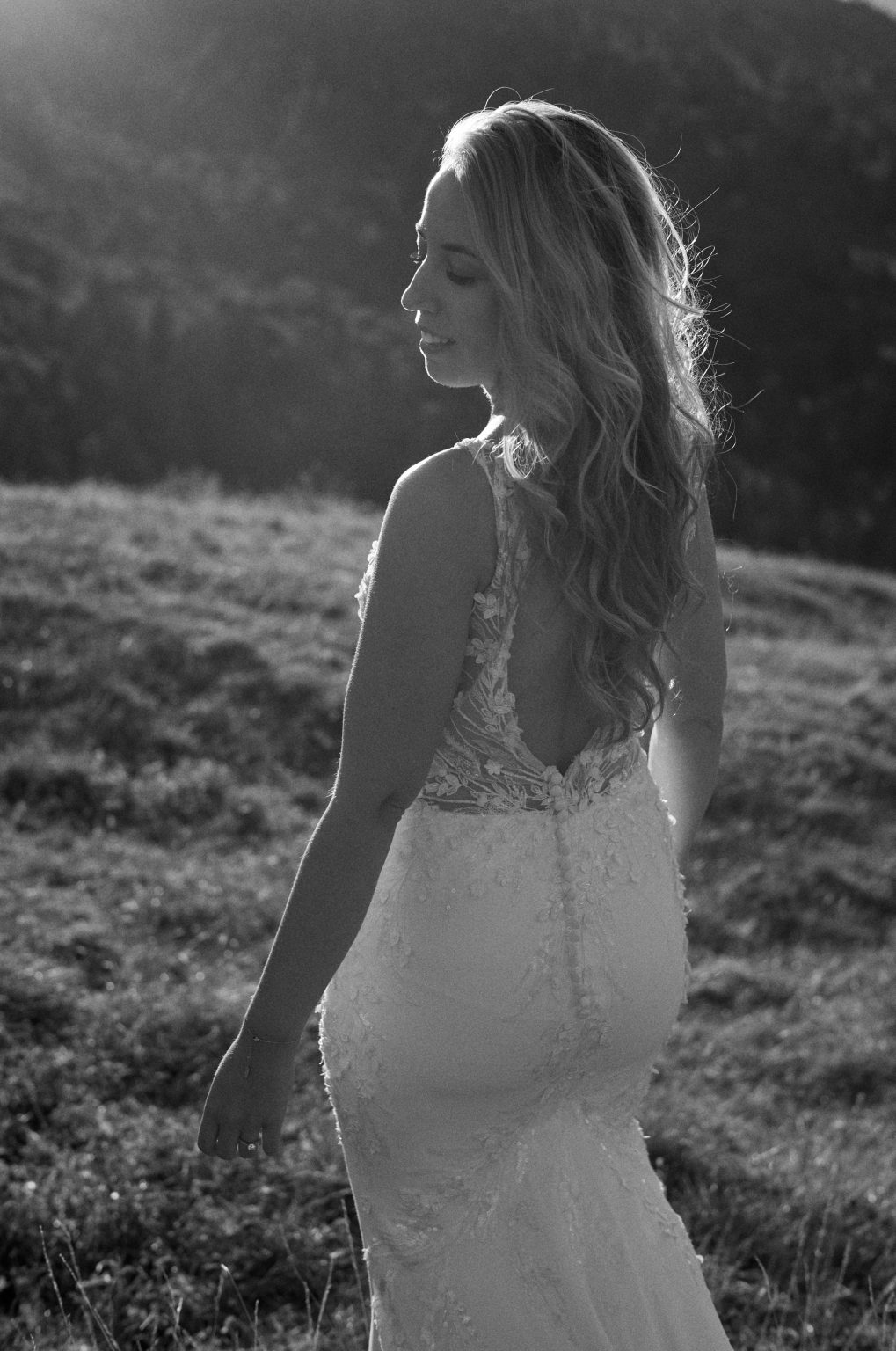 Bride walking through the grass at dusk, black and white, Dolomites