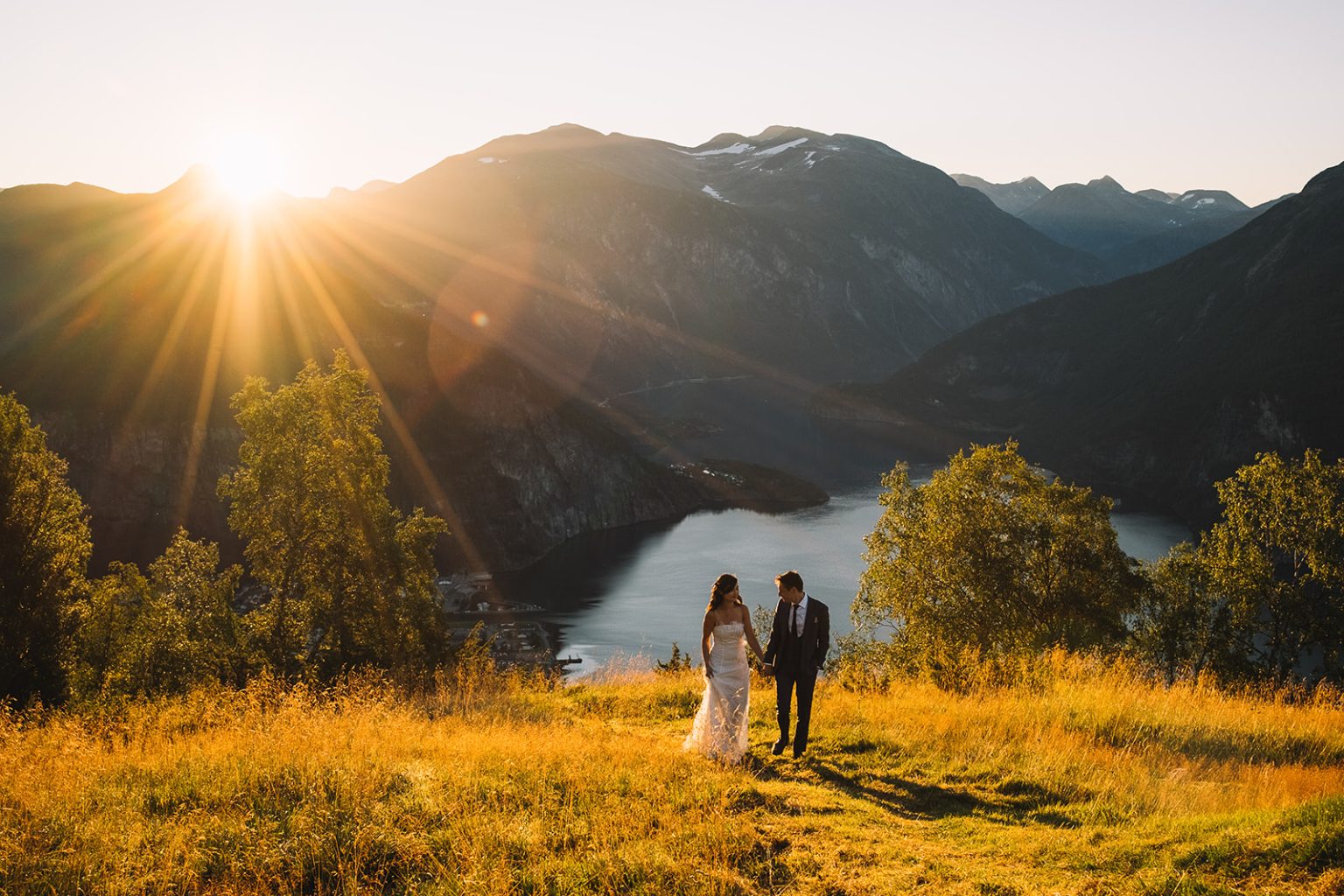 The couple tiny beneath the sunrise mountains, Juvet Landscape Hotel