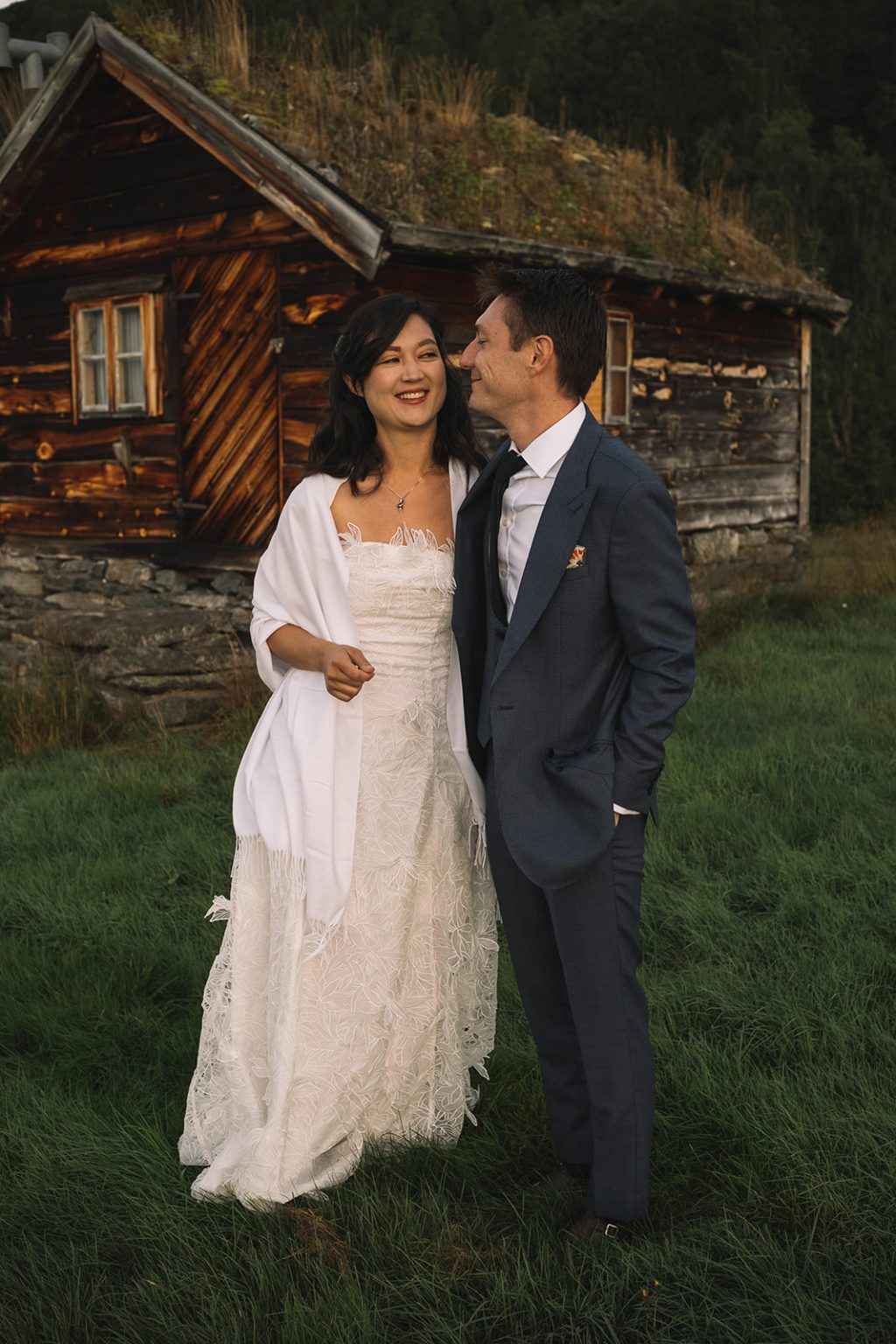 Ida and James by a turf-roofed cabin at dawn, Norway wedding