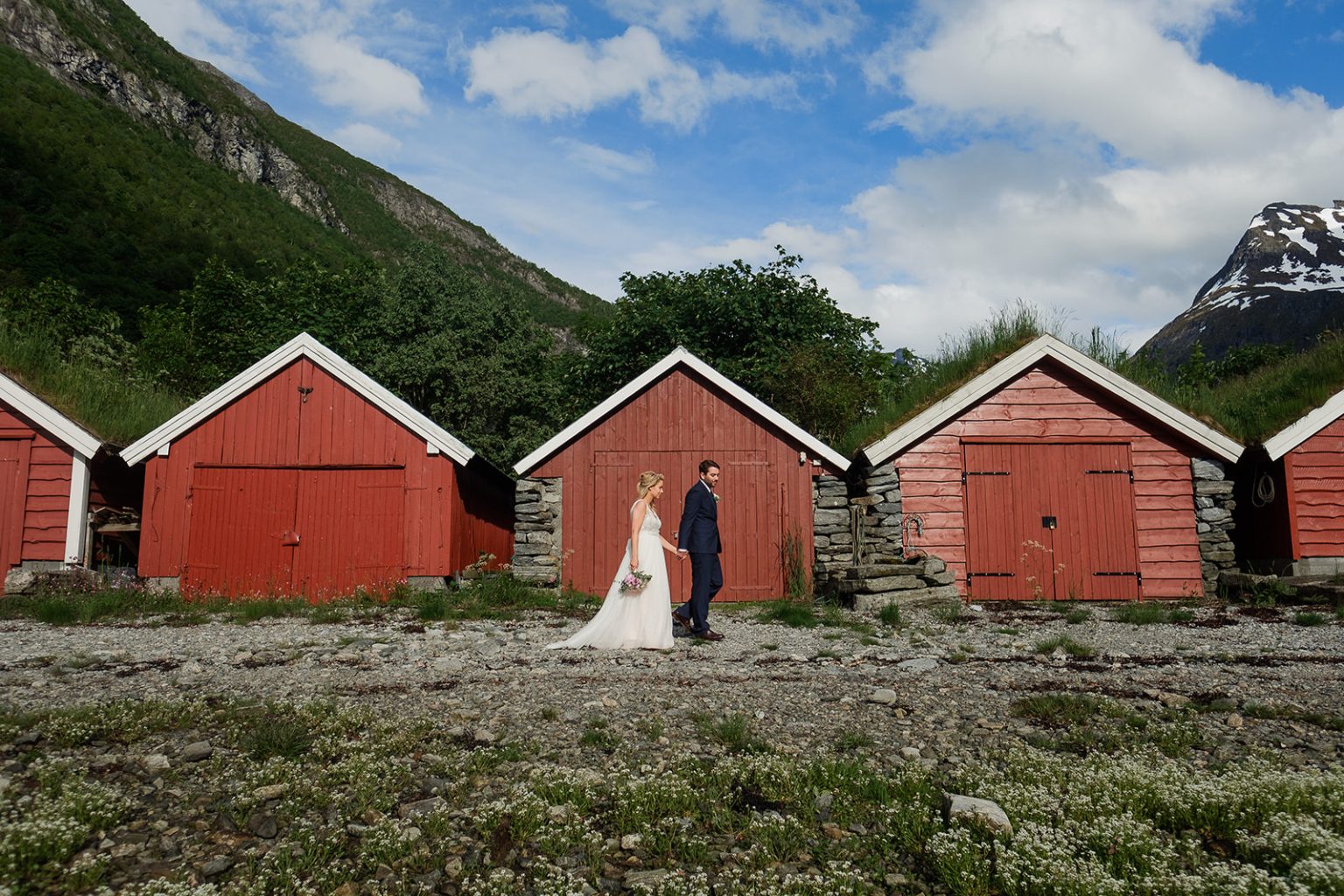 Bride and groom by the red boathouses at Øye