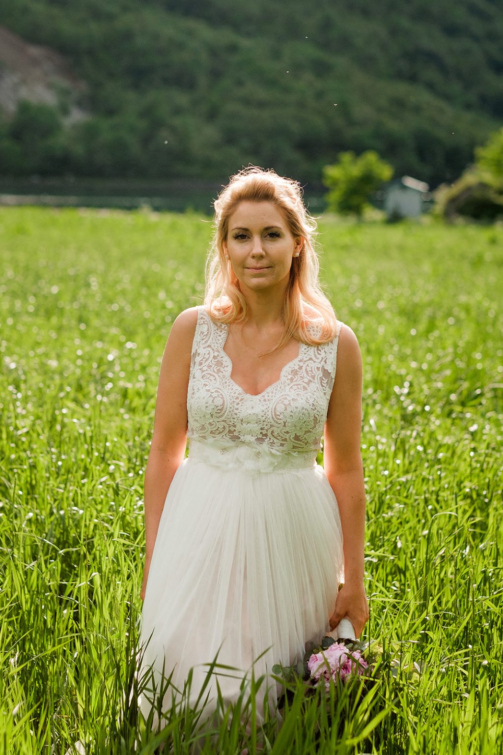 Bride in a green meadow below the mountains at Øye