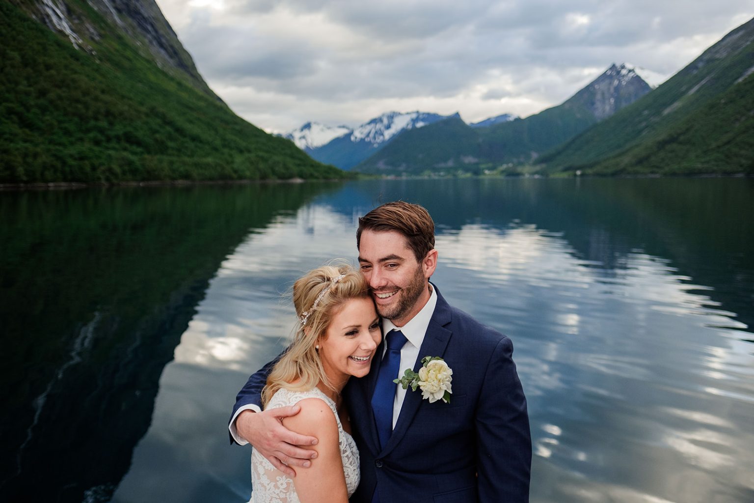 Bride and groom reflected in the still fjord, Union Øye elopement