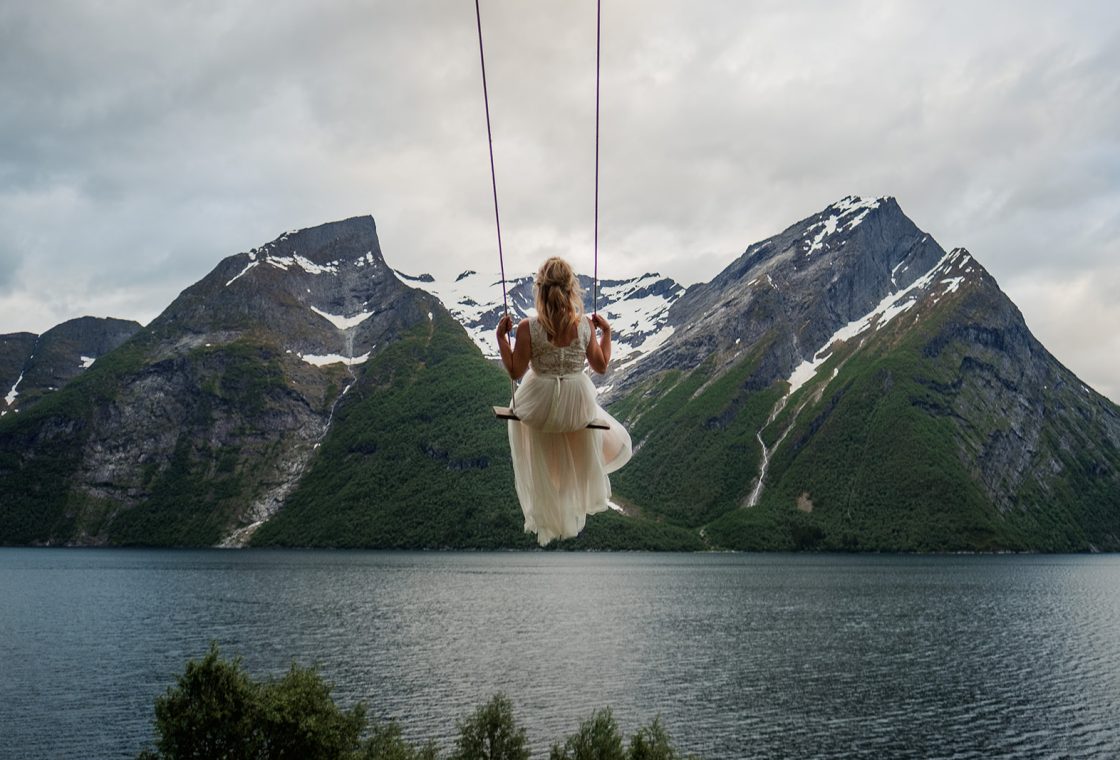 Bride on a swing out over the fjord, a Hotel Union Øye elopement