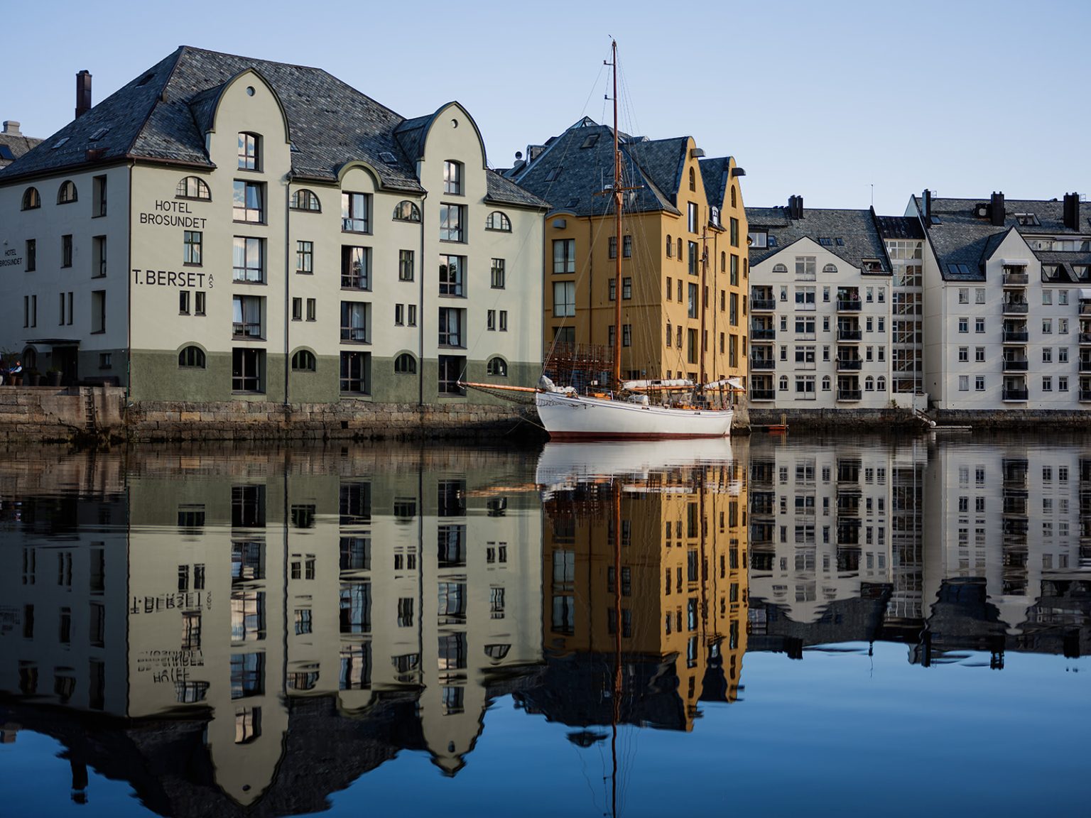 The art nouveau harbour of Ålesund reflected in still water
