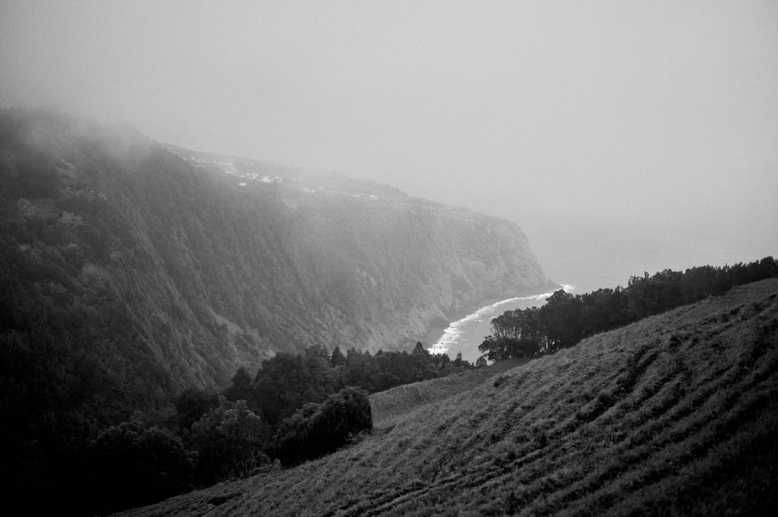 Misty green cliffs and terraced hills on the São Miguel coast