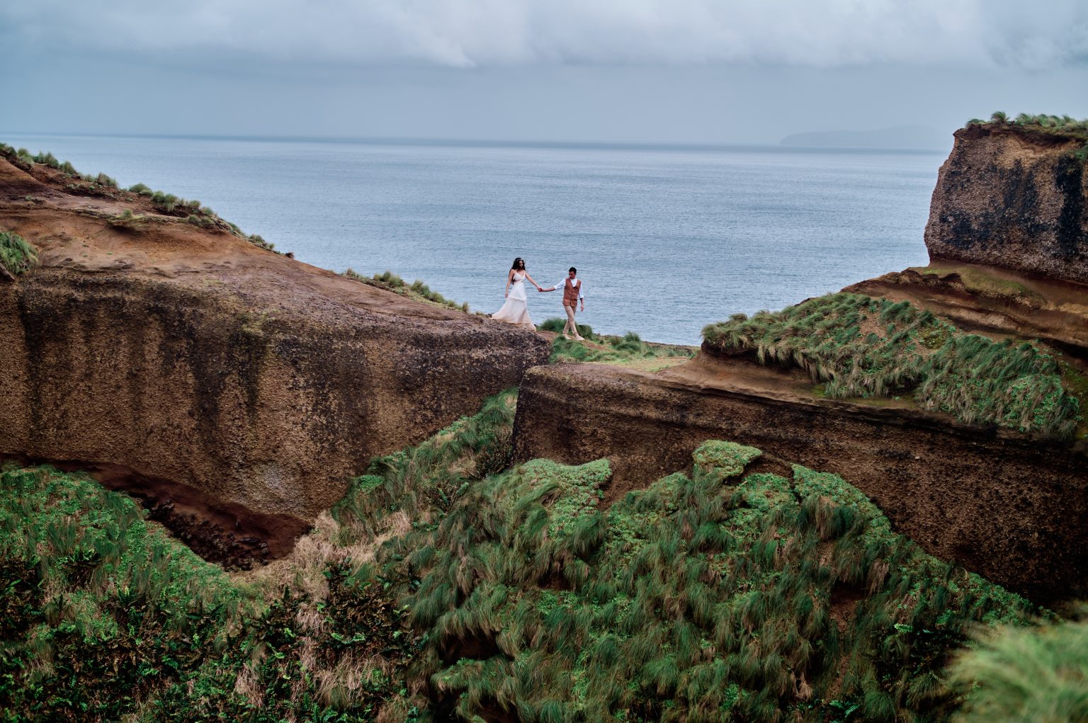 The couple on green clifftops over the ocean, São Miguel