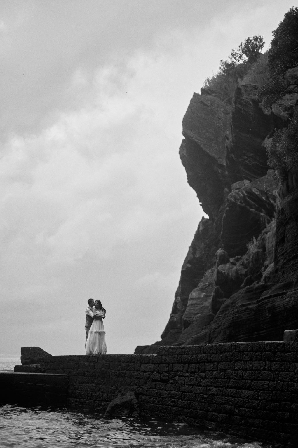 Silvia and Florin small below a huge cliff on the São Miguel coast