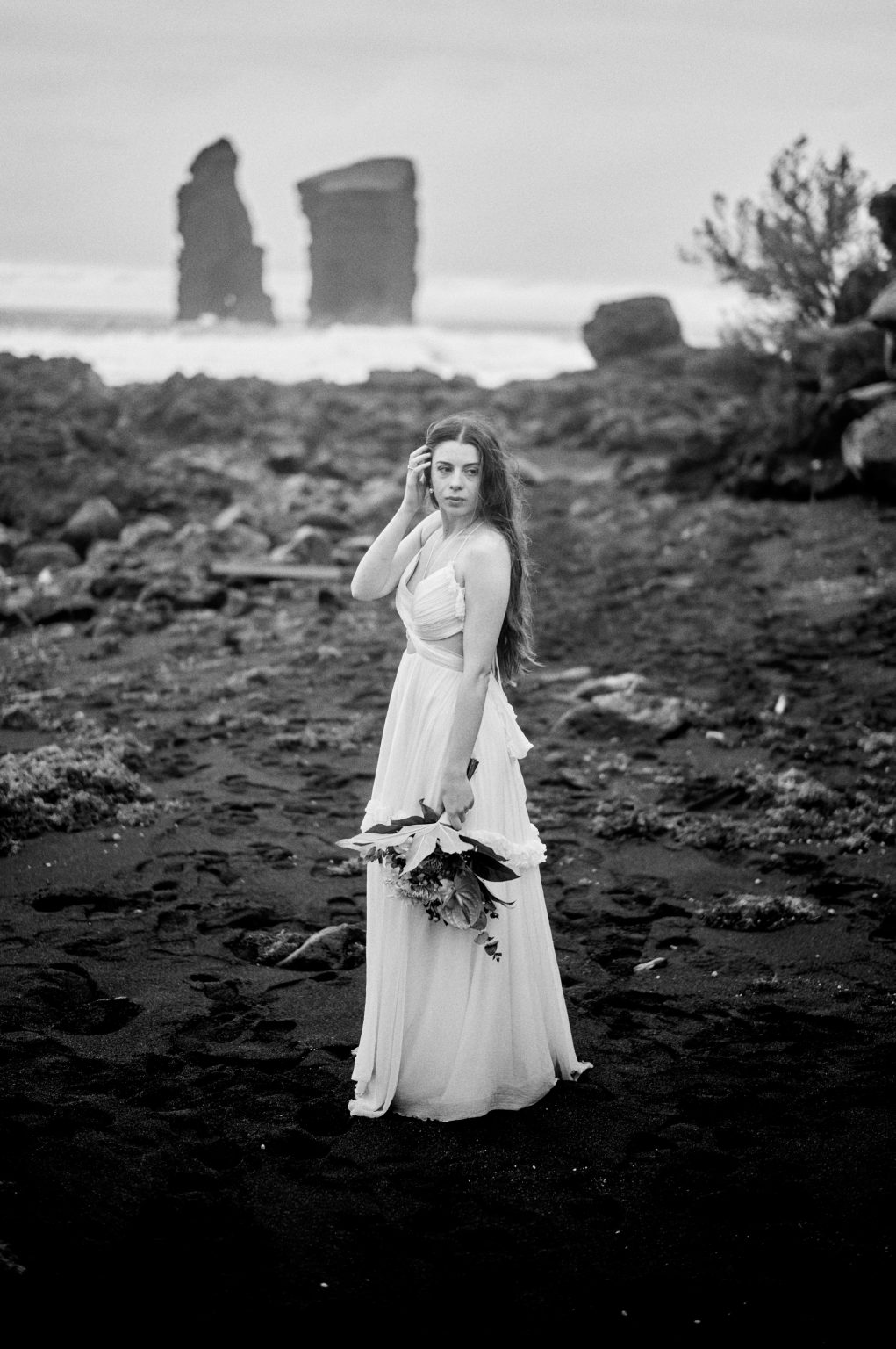 The bride with her bouquet before the Mosteiros sea stacks