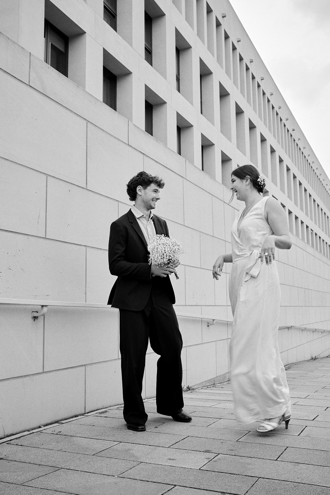 Black and white engagement photo of a couple with a bouquet in Berlin - Nordica Photography
