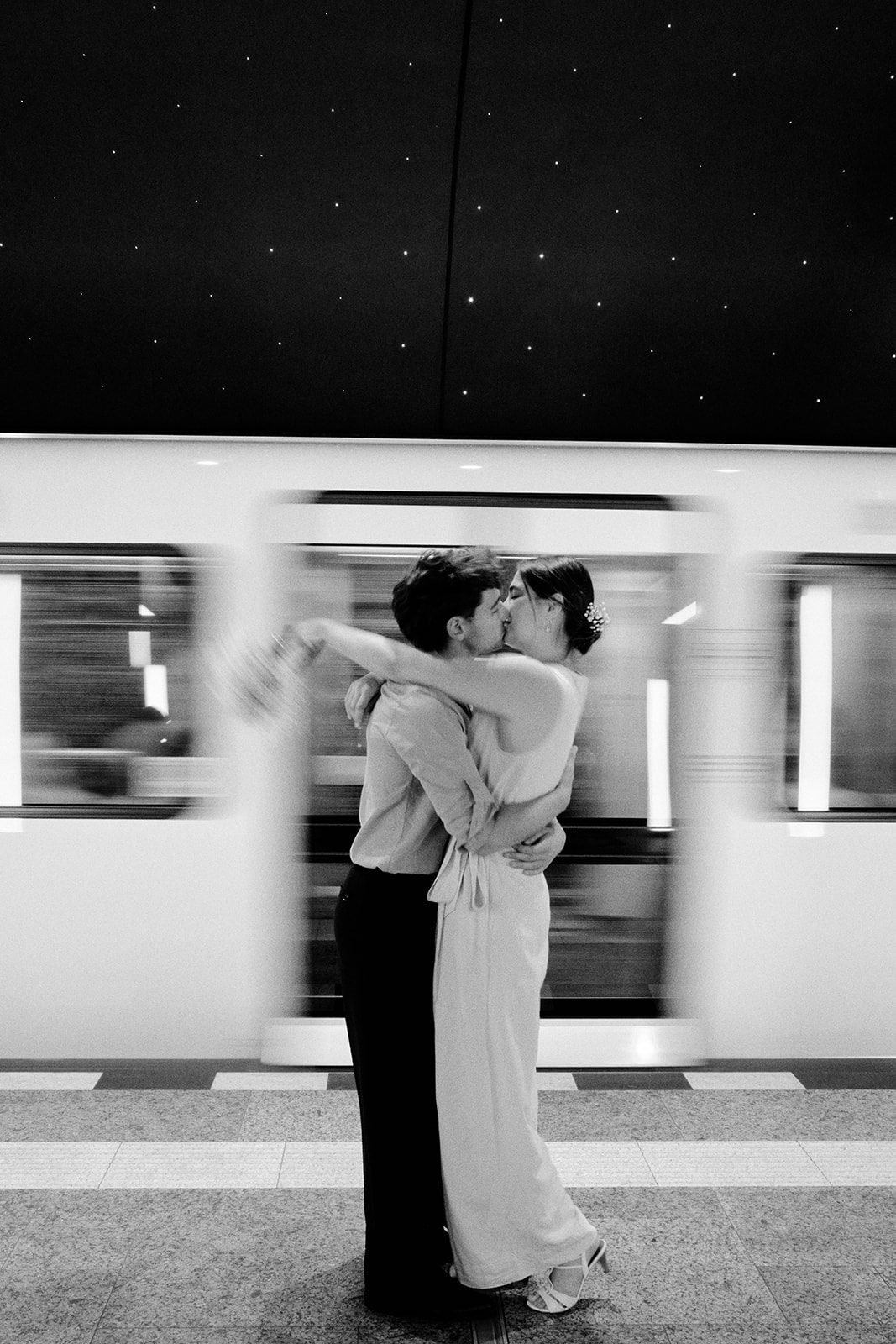 Couple kissing as a train passes on the Berlin U-Bahn, black and white engagement - Nordica Photography