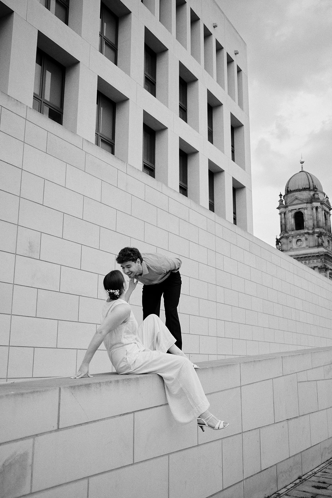 Couple by a wall with the Berlin cathedral behind, black and white engagement - Nordica Photography