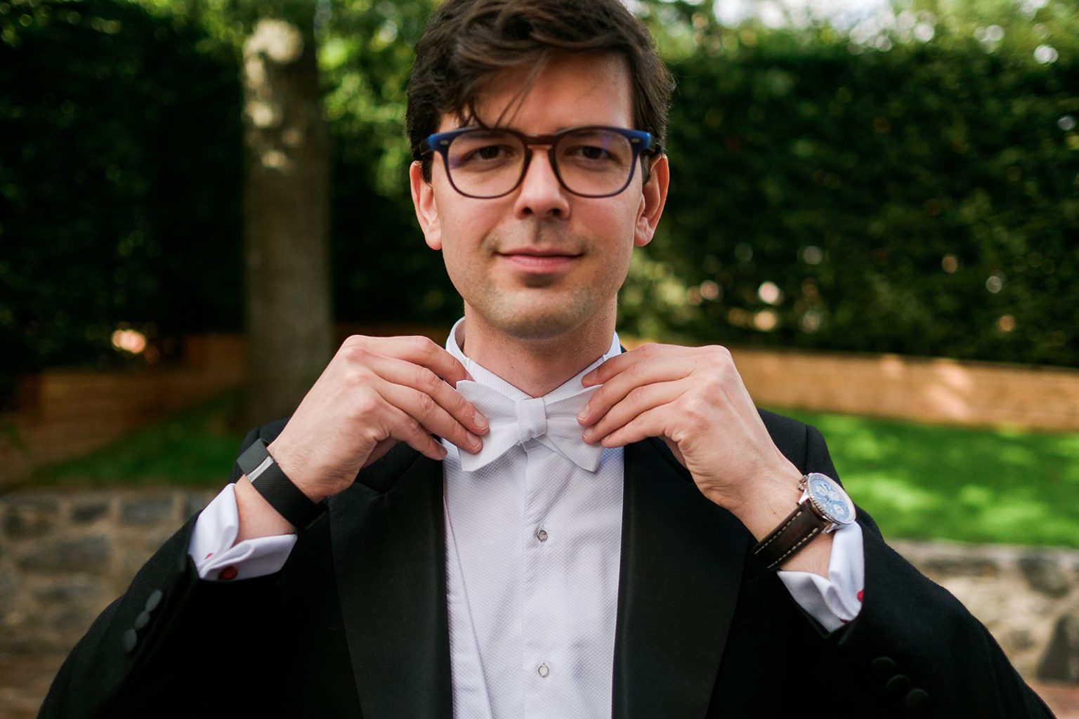 Groom fastening his bow tie