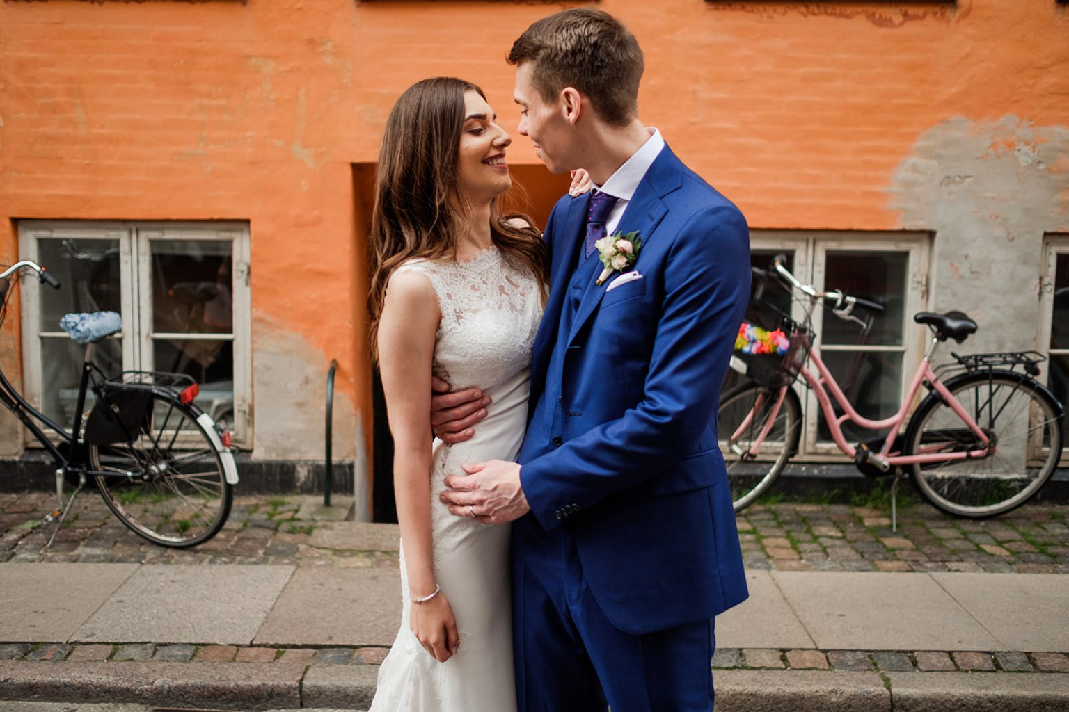 Bride and groom against a painted wall in Copenhagen