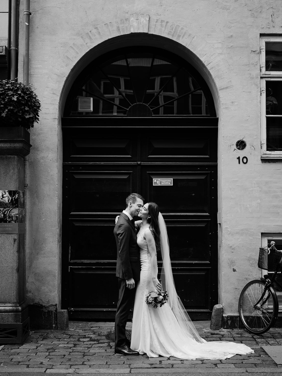 Bride under a stone archway in Copenhagen