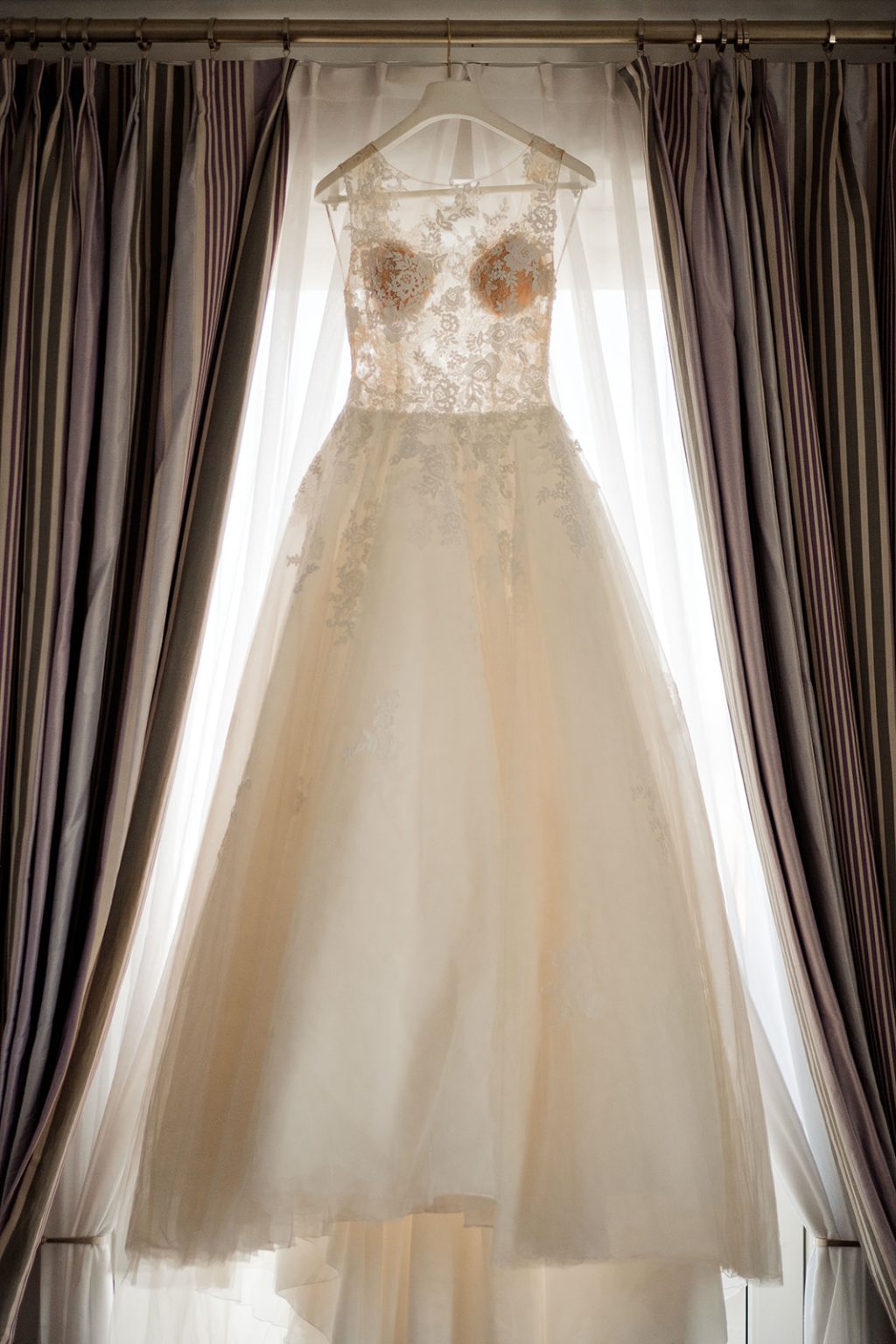 The bride’s dress hanging at the hotel window
