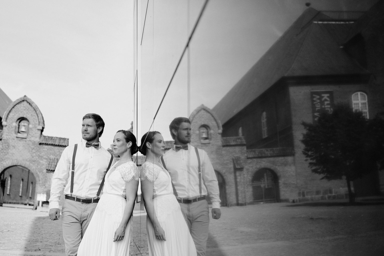 Caroline and Rasmus by a brick church in Copenhagen, black and white