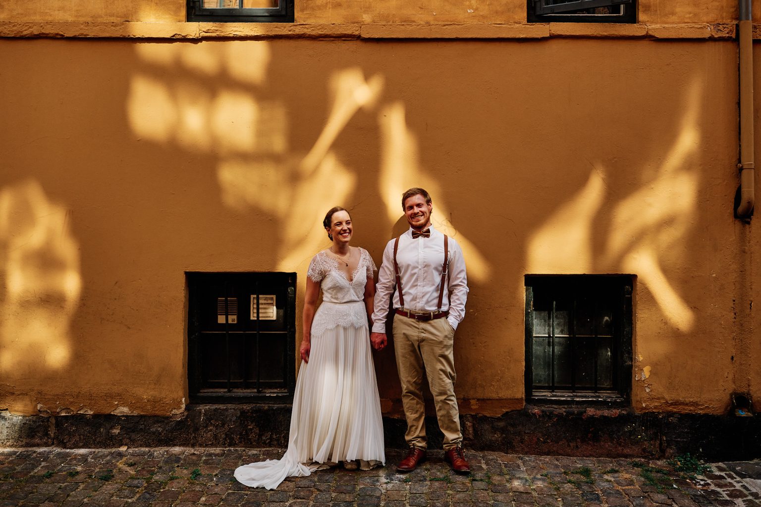 Couple against a yellow Copenhagen facade, Copenhagen engagement session