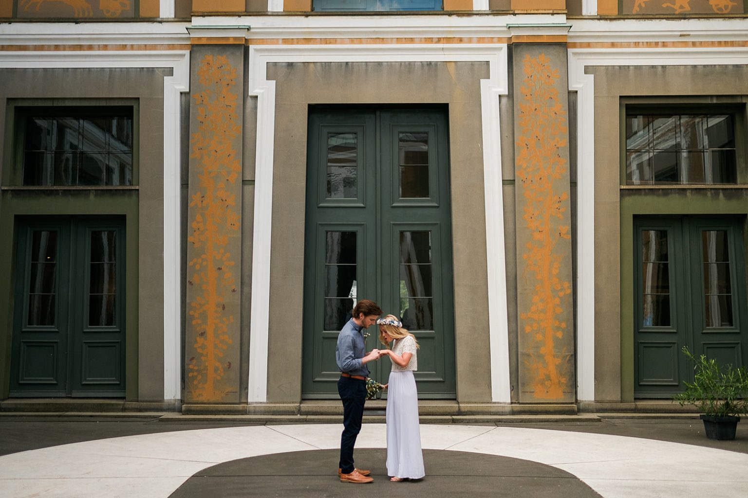 Bride and groom small against a grand Copenhagen building
