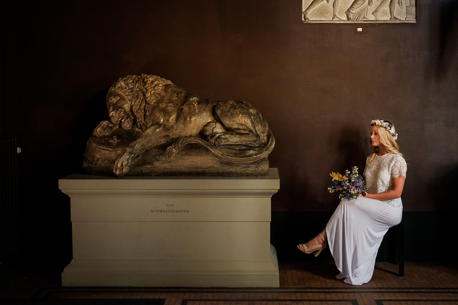 The bride beside a lion sculpture in the museum