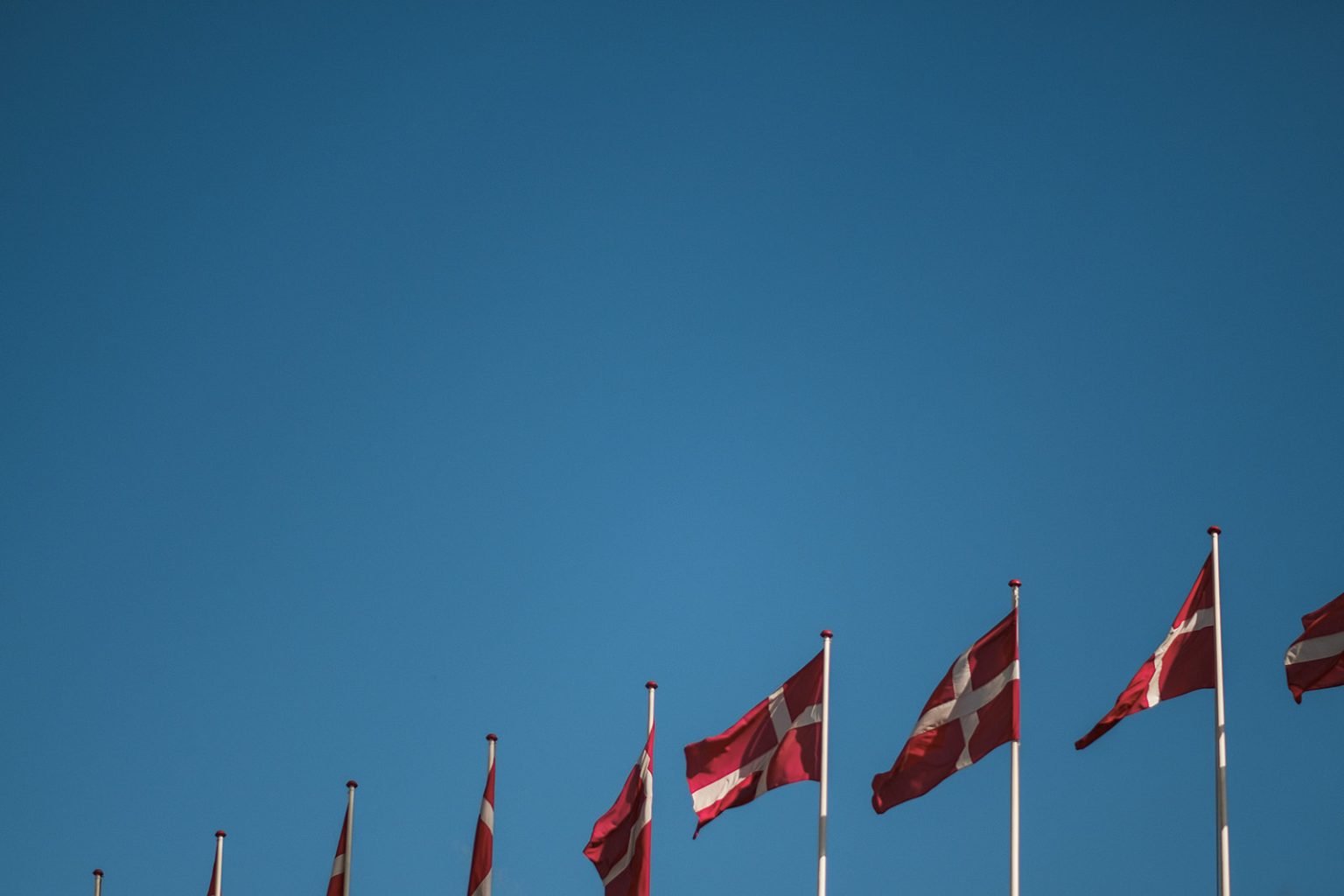 Danish flags against a blue sky in Copenhagen