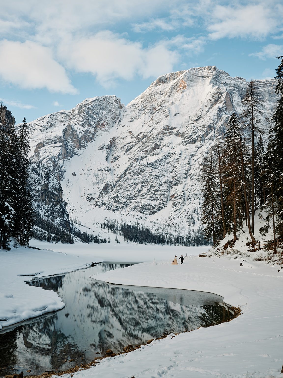 A frozen curve of Lago di Braies below the peaks, a Dolomites winter elopement
