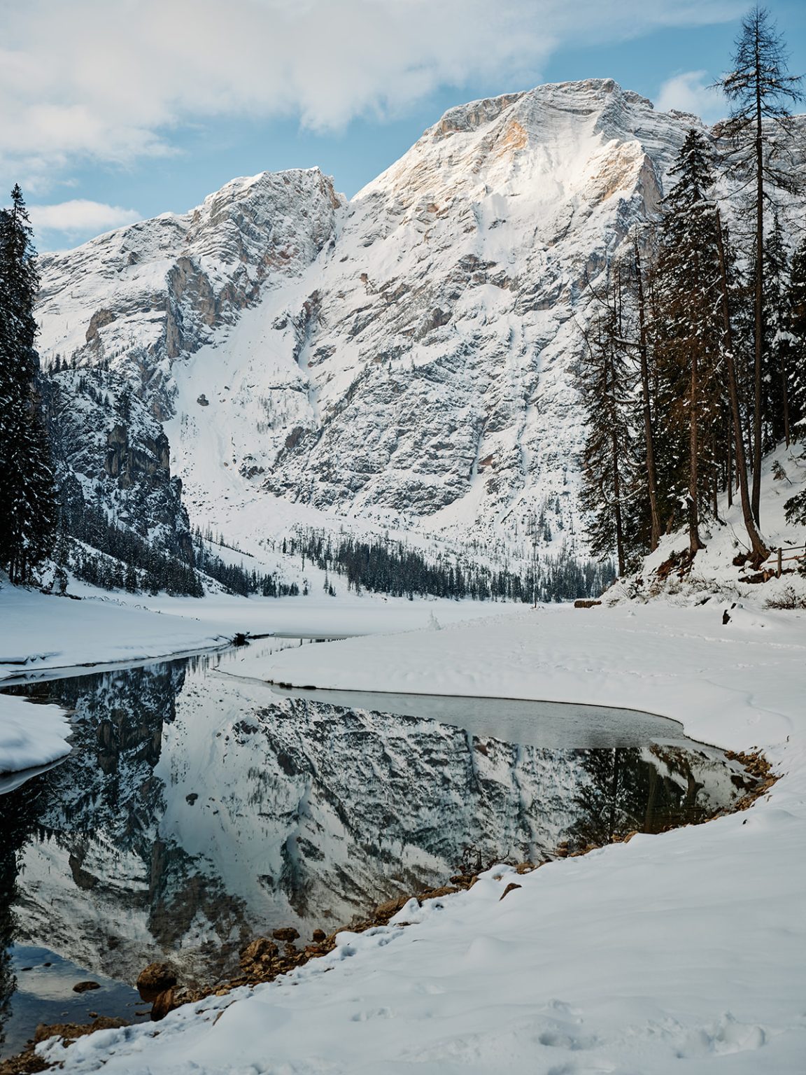 Snowy peaks reflected in Lago di Braies, a Dolomites winter elopement