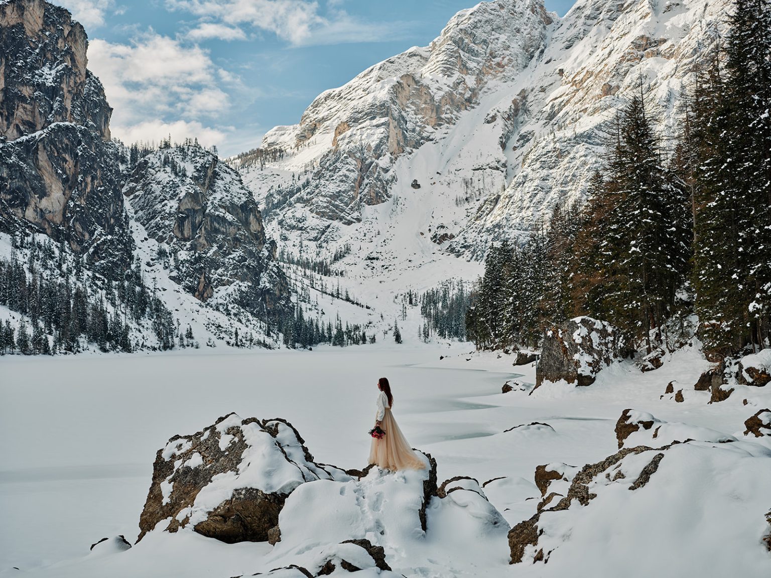 The couple among snow and rock at Lago di Braies, a winter elopement