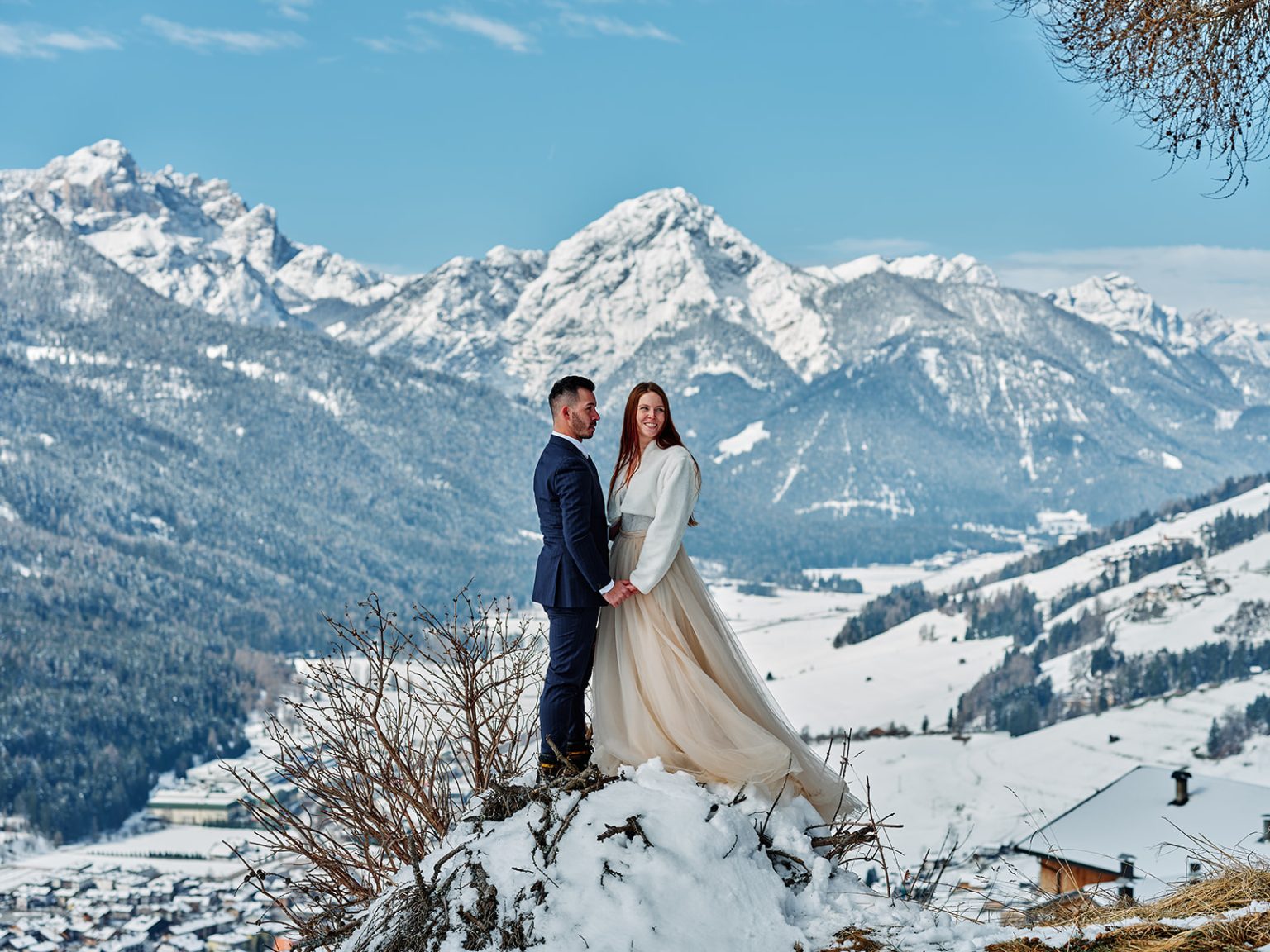 The couple embracing below the Braies peaks, a Dolomites winter elopement