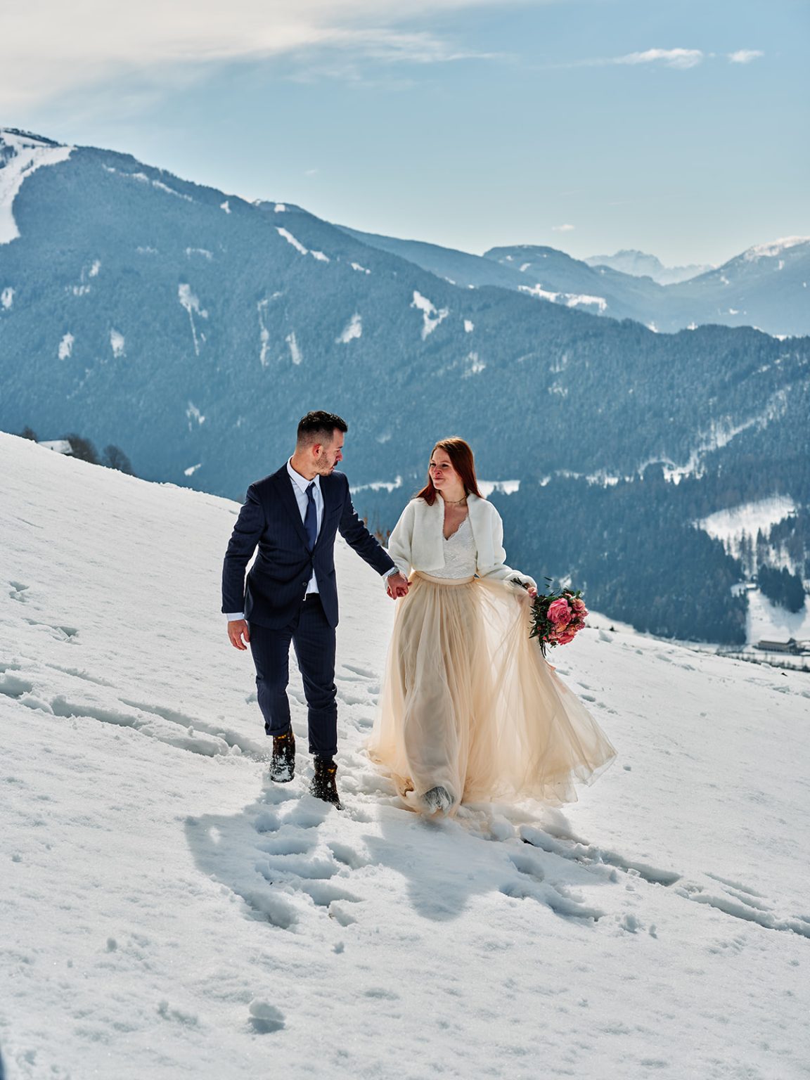 The couple walking hand in hand at Passo Giau, a Dolomites winter elopement