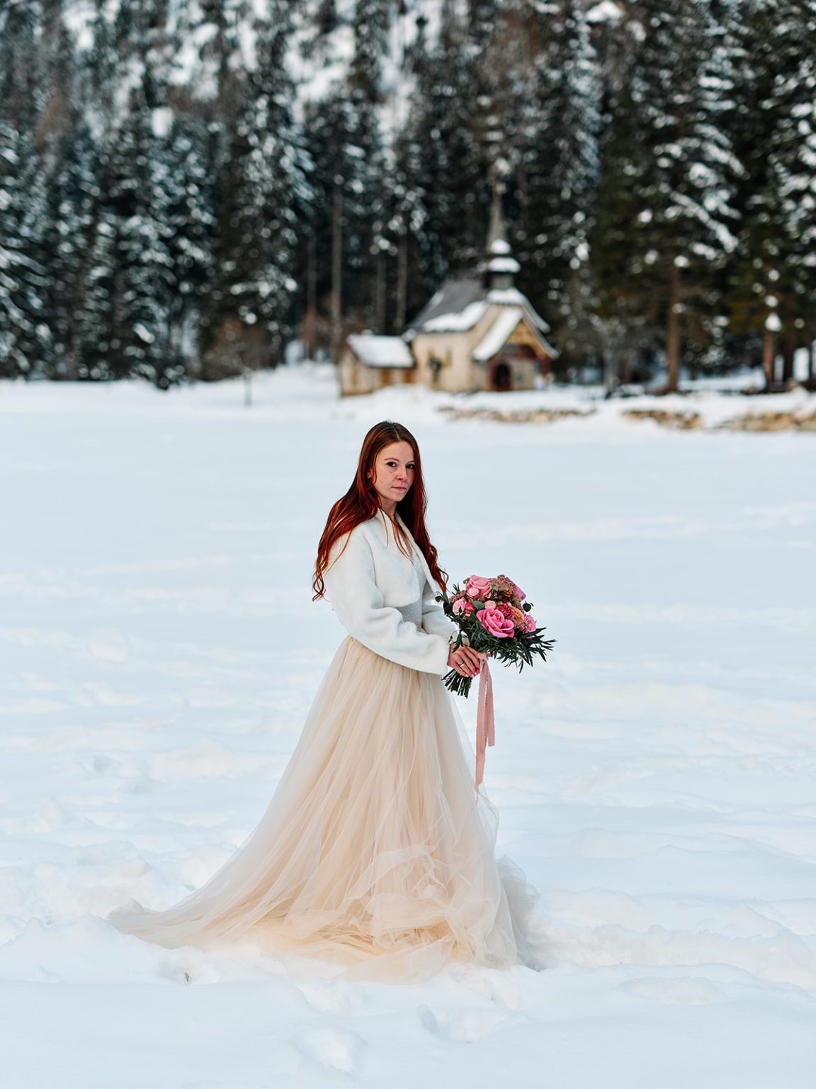 Kristina with her bouquet in the snow, a Dolomites winter elopement