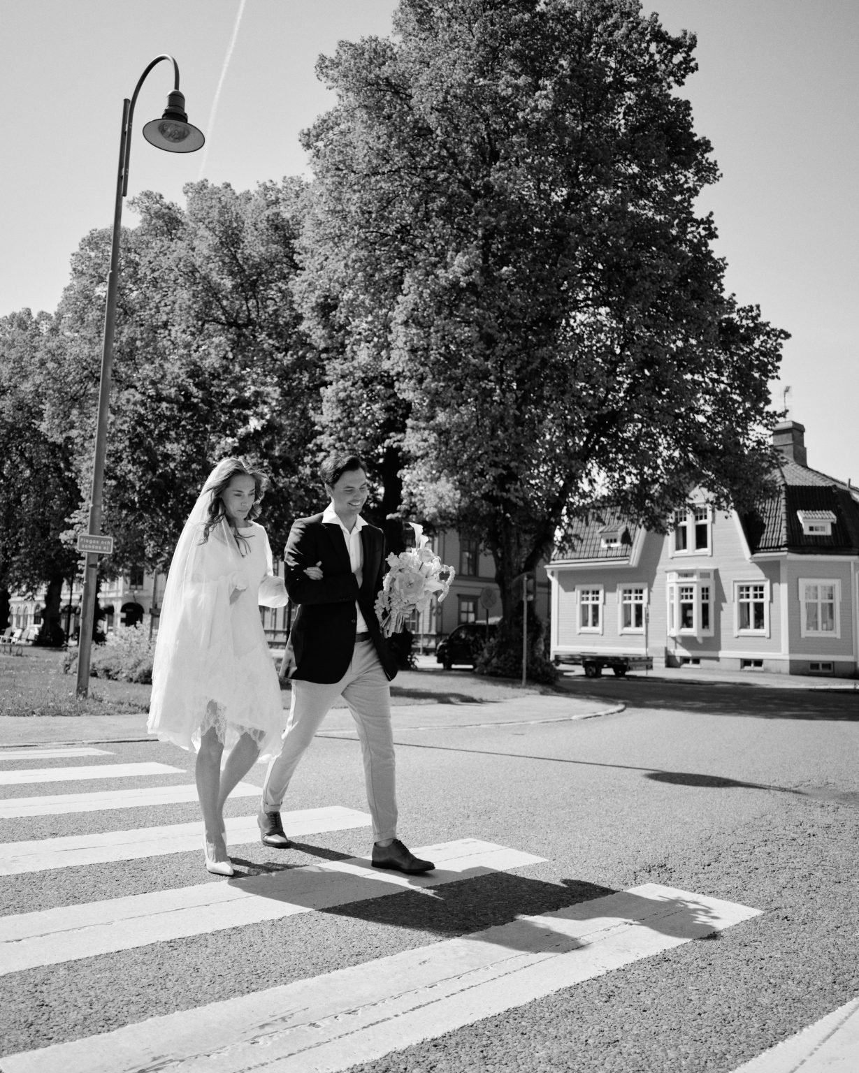 Elin and Joakim crossing a street in the middle of Söderhamn on their elopement day